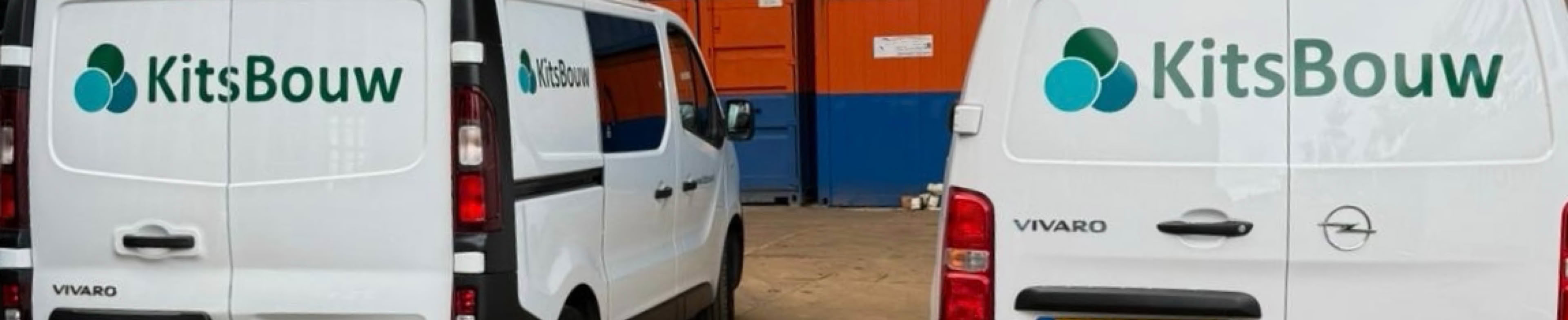 Twee witte werk bussen met het logo "KitsBouw" geparkeerd voor gekleurde containers op een bouwplaats.